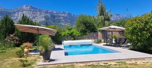 a swimming pool in a backyard with a mountain at Chambre d'hôte de Reymure in Vif