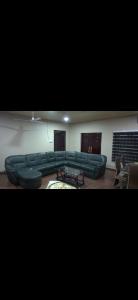 a living room with green couches and a table at Sunlight Guest house in Ofankor