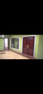 two wooden doors in a room with two windows at Sunlight Guest house in Ofankor