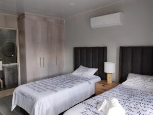 a bedroom with two beds with white sheets at The Room Above in Brackenfell
