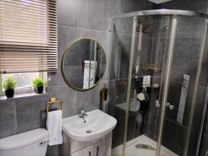 a bathroom with a shower and a sink and a mirror at The Room Above in Brackenfell +31 photos