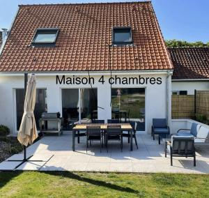 a patio with a table and chairs in front of a house at Gîte du Flot - Baie de Somme in Boismont