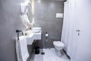 a bathroom with a toilet and a sink and a mirror at Dorá Hotel Buenos Aires in Buenos Aires +42 photos
