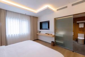 a hotel room with a bed and a television at Hera Hotel in Hanoi