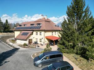 a house with cars parked in a parking lot at Mlyn Tatry Resort in Veľký Slavkov