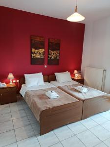 a bedroom with a large bed with a red wall at SmallHotel - Vevi in Vévi