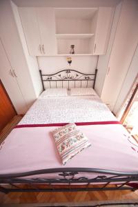 a small bedroom with a bed with a pillow on it at Apartments Vila Miranda in Barbat na Rabu