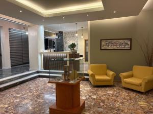 a lobby with two yellow chairs and a glass table at Neda Hotel in Olympia +60 photos