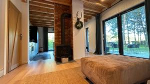 a bedroom with a fireplace and a bed in a room at Forest Cabin Modern Barn and Private Woods in Jamielnik