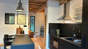 a kitchen with a black counter and a sink at Forest Cabin Modern Barn and Private Woods in Jamielnik +25 photos