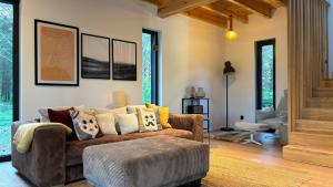 a living room with a couch and a chair at Forest Cabin Modern Barn and Private Woods in Jamielnik
