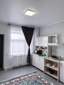a kitchen with a large window and a kitchen at Gatto in Bishkek