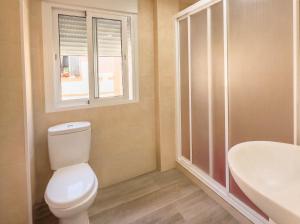 a bathroom with a toilet and a sink and a window at Sun Serramar Boutique Hostal in Benalmádena +46 photos