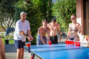a group of people standing around a ping pong table at Luna in Lierna