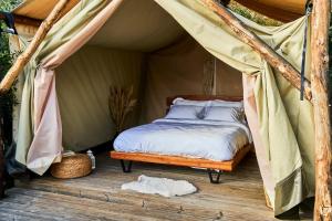 a bed in a tent on a wooden deck at Billion Stars in Thymonia Beach