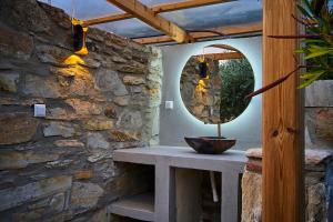 a stone wall with a table and a mirror at Billion Stars in Thymonia Beach