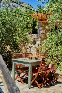 a picnic table with chairs and an umbrella at Billion Stars in Thymonia Beach