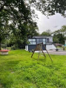 a swing set in a yard in front of a house at Chez Virginie in Rhodes