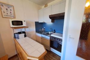 a small kitchen with a sink and a microwave at Studio at the foot of the ice rink in Le Grand-Bornand