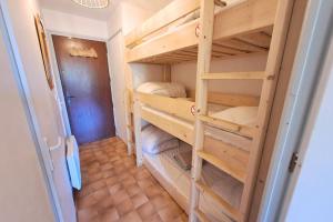 a room with two bunk beds in a room at Studio at the foot of the ice rink in Le Grand-Bornand