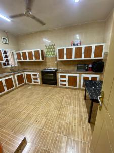 a large kitchen with wooden floors and cabinets at شقة عوقد in Okkad
