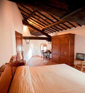 a bedroom with a large bed and a dining room at La Soffitta e La Torre in Orvieto