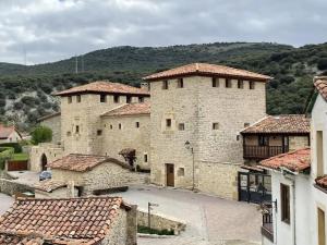 a large stone building with red tile roofs at APARTAMENTOS PUENTEDEY in Puentedey