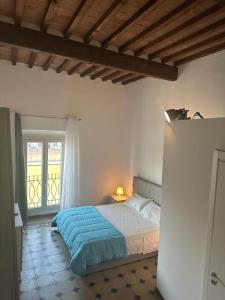 a bedroom with a bed and a balcony with a window at Lungarno Suite in Pisa