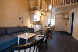 a living room with a couch and a table with chairs at Bygdsiljums Sjöbodar in Bygdsiljum +13 photos