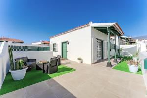 a patio with grass and furniture on a house at BUNGALOW ATALAYA in Abades