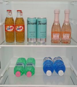 a refrigerator filled with bottles and cans of soda at DOS Gardenias B&B in Pozzuoli