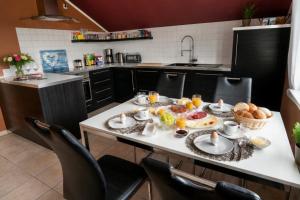 a kitchen with a breakfast table with food on it at Ferienwohnung Blumäcker Oberbayern in Oberhausen +65 photos