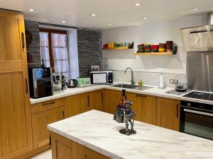 a kitchen with a counter with a bottle of wine on it at Domaine-Bayard avec grande piscine privative et climatisation in Bergesserin