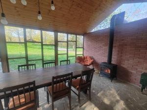 a dining room with a table and a wood stove at Jvarisa Glamping in Ambrolauri
