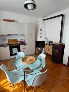 a dining room with a glass table and chairs at Cottage di Lola in Fonteno +9 photos