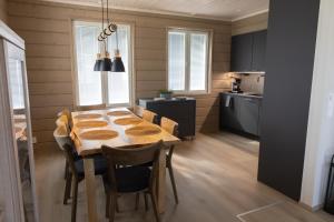 a kitchen with a wooden table with chairs and a dining room at Villa Aattu in Muonio
