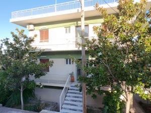 a white building with stairs leading up to it at Puente Rooms in Methana