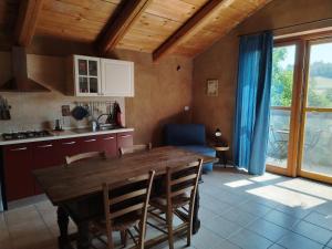 a kitchen and dining room with a wooden table and chairs at I Conti della Serva in Cinzano