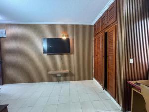 a room with a television on a wall with a tile floor at Lux meublé in Douala