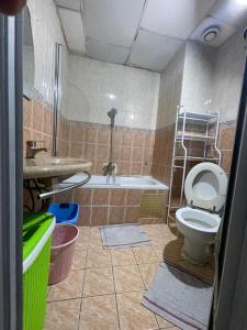 a bathroom with a toilet and a sink and a tub at Lux meublé in Douala