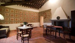 a living room with a table and chairs and a fireplace at La Soffitta e La Torre in Orvieto