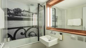 a bathroom with a sink and a mirror at Campanile NATURE - Biarritz in Biarritz +32 photos