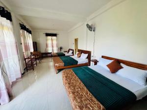 a hotel room with two beds and a couch at Ayubowan, Ella in Ella