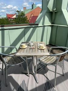 a wooden table and chairs on a balcony at Hotel Stensson in Eslöv