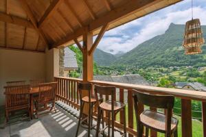 a balcony with chairs and a table and a view at Les Chalets de l'Ours in Cauterets