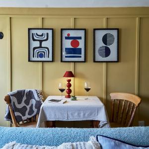 a table with two chairs and two glasses of wine at NEW Stylish Cosy Dog Friendly Cottage Parking Central in Oundle