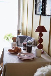 a table with a plate of croissants and a lamp at NEW Stylish Cosy Dog Friendly Cottage Parking Central in Oundle