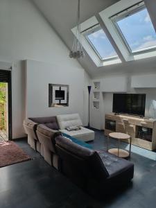 a living room with a couch and a tv at Petite pom in Azay-le-Rideau