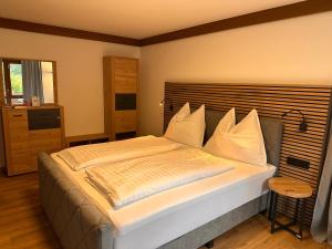a bedroom with a large bed with white pillows at Hotel Haus Sonnblick in Bad Kleinkirchheim