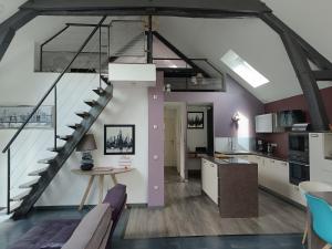 a kitchen and living room with a staircase in a loft at Petite pom in Azay-le-Rideau